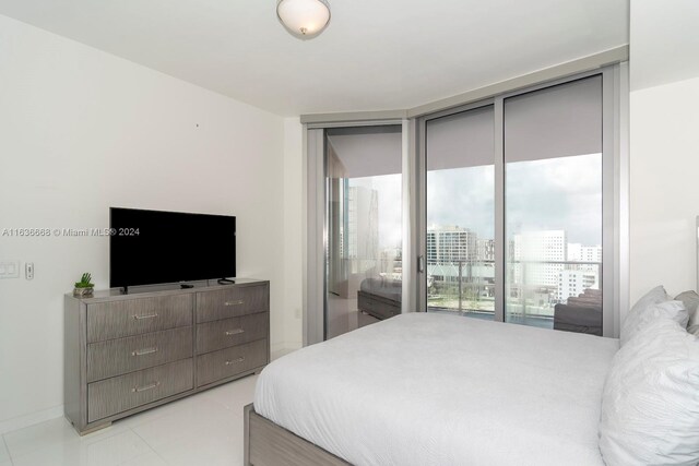 bedroom featuring access to exterior, a wall of windows, and light tile patterned floors