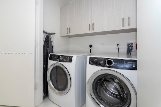 laundry area with washing machine and dryer and cabinets