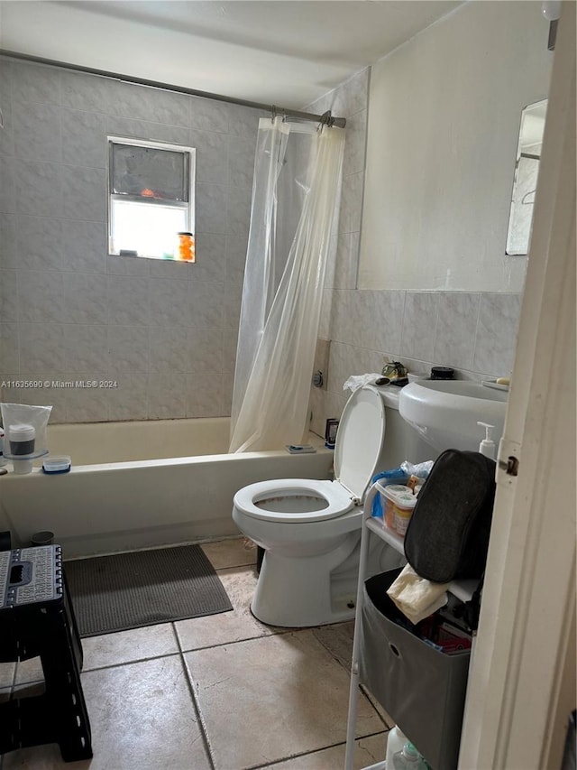 bathroom with tile walls, toilet, shower / tub combo with curtain, and tile patterned floors