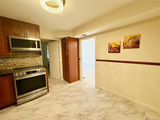 kitchen featuring oven, light tile patterned floors, and decorative backsplash