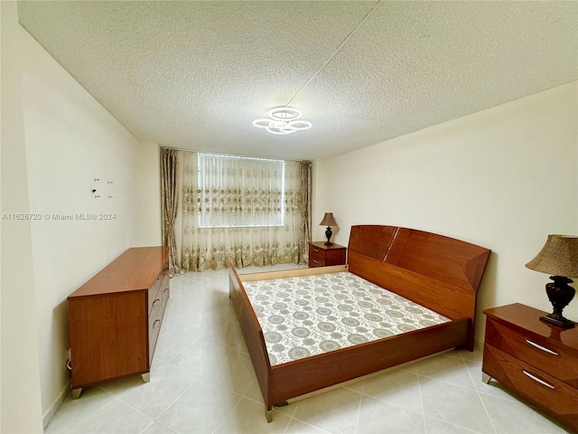 bedroom with light tile patterned flooring and a textured ceiling