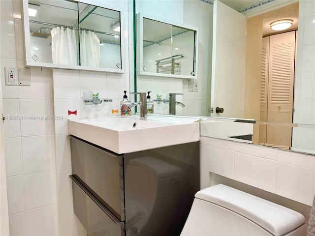 bathroom featuring tile walls, toilet, and vanity