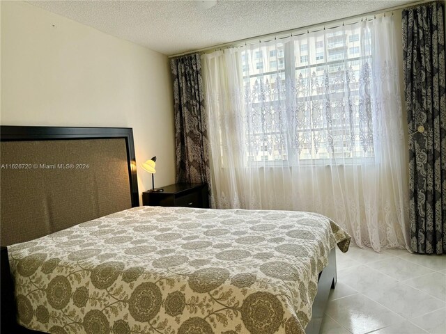 tiled bedroom with a textured ceiling