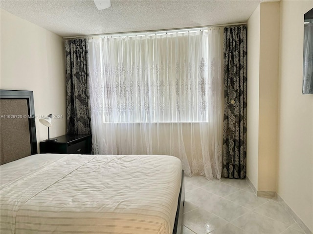 bedroom featuring light tile patterned floors and a textured ceiling