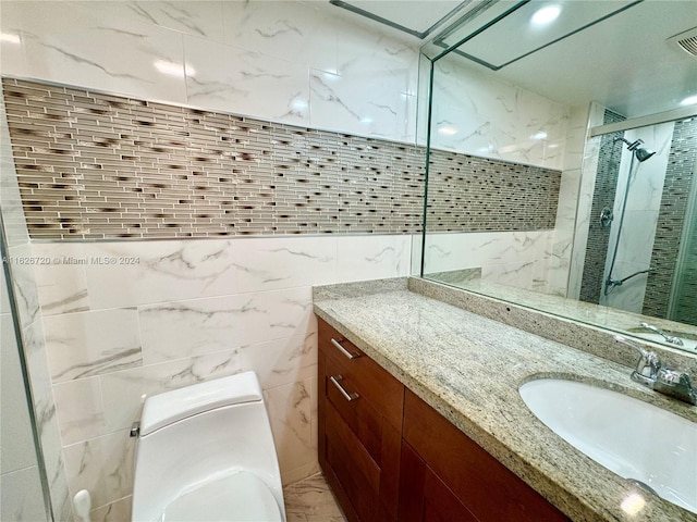 bathroom with tile walls, toilet, and vanity