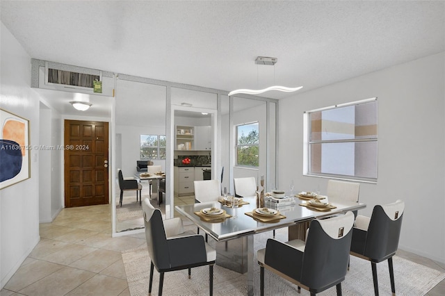 tiled dining room featuring a textured ceiling