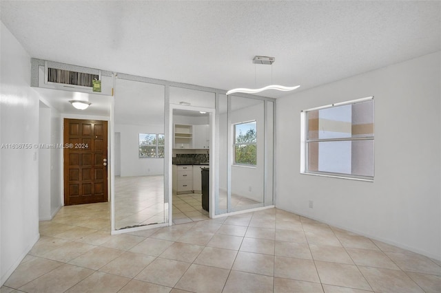 unfurnished bedroom featuring a textured ceiling and light tile patterned floors