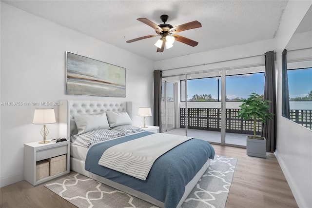 bedroom featuring a textured ceiling, ceiling fan, access to outside, and light wood-type flooring