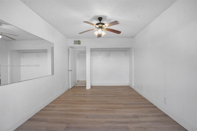 interior space with ceiling fan, a textured ceiling, and wood-type flooring