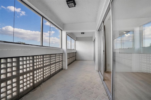 hall with a textured ceiling and tile patterned flooring