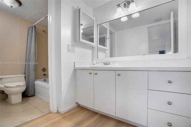 full bathroom with toilet, hardwood / wood-style floors, vanity, and shower / bath combo