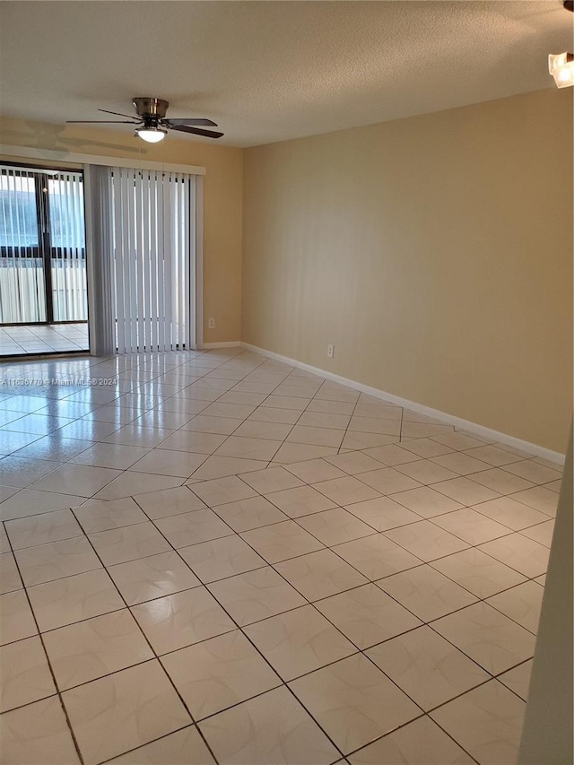 unfurnished room featuring light tile patterned floors, a textured ceiling, a ceiling fan, and baseboards