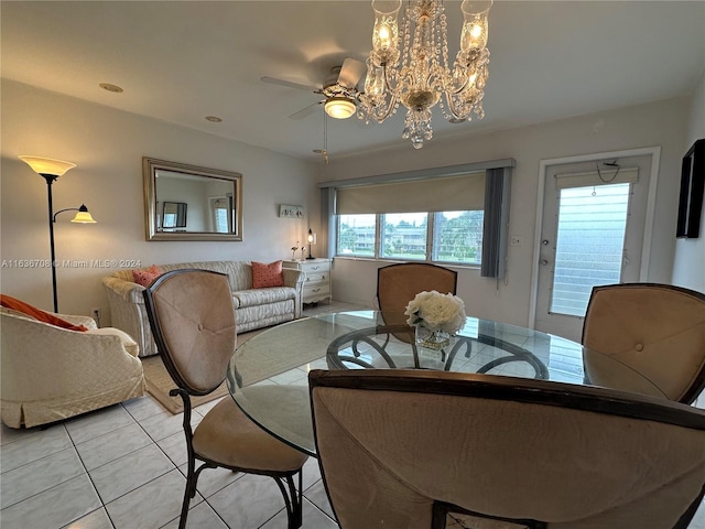 tiled dining room featuring ceiling fan with notable chandelier