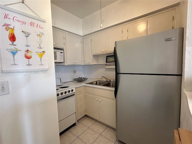 kitchen with sink, light tile patterned floors, and white appliances