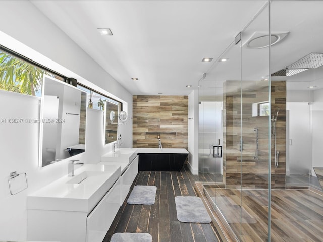 bathroom with dual vanity, a shower with shower door, and hardwood / wood-style floors