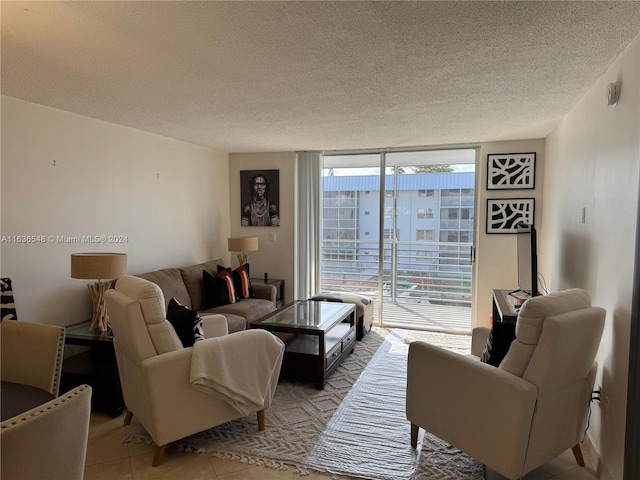 living room with a textured ceiling, expansive windows, and light tile patterned flooring