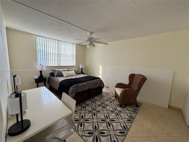 tiled bedroom featuring a textured ceiling and ceiling fan