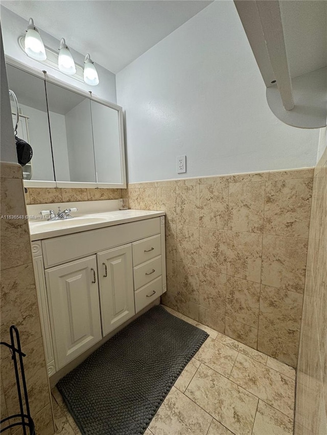 bathroom with vanity and tile walls