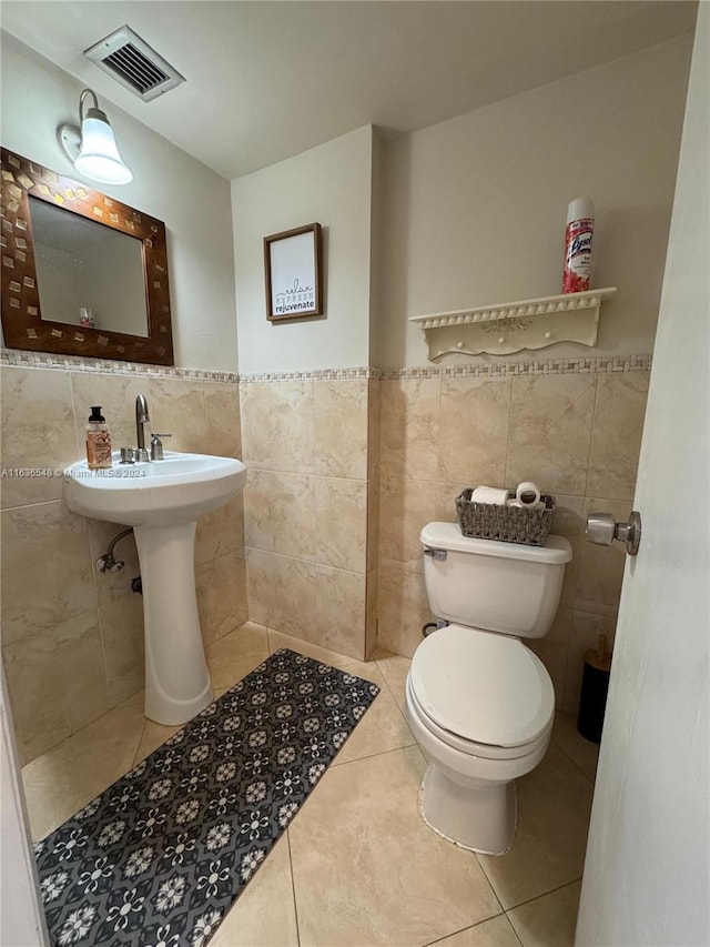 bathroom featuring tile patterned floors, tile walls, and toilet