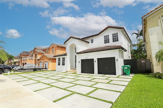 mediterranean / spanish house featuring a front lawn and a garage