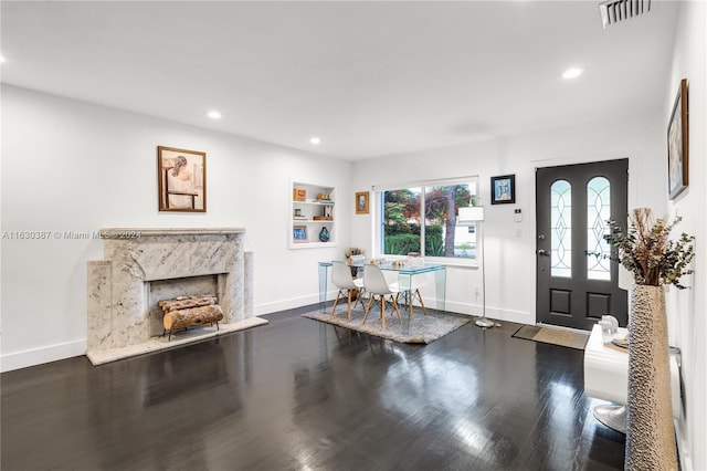 foyer with a fireplace and dark wood-type flooring