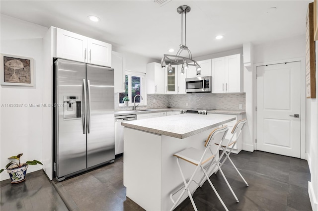 kitchen with white cabinetry, decorative light fixtures, tasteful backsplash, and appliances with stainless steel finishes