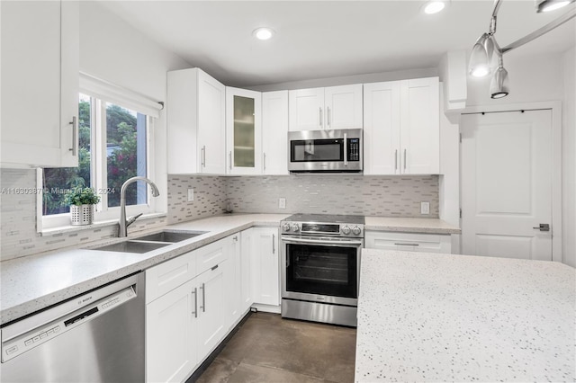 kitchen featuring tasteful backsplash, hanging light fixtures, appliances with stainless steel finishes, and sink