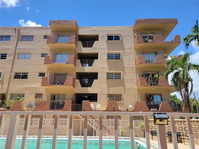 view of property with a community pool and fence