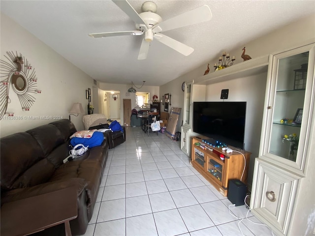 living room featuring ceiling fan, light tile patterned floors, and a textured ceiling