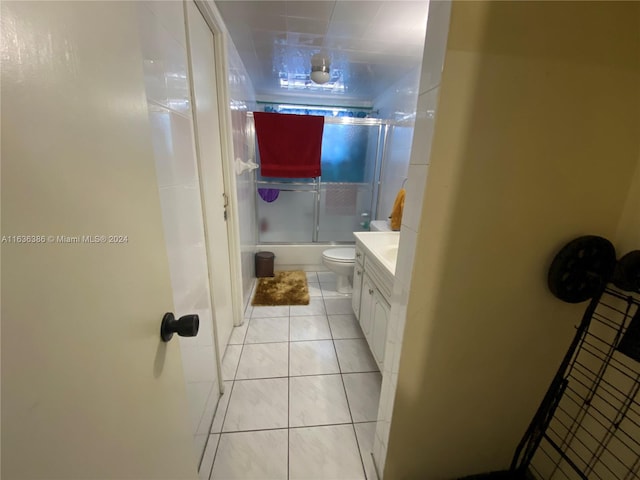 full bathroom featuring enclosed tub / shower combo, toilet, tile patterned floors, and vanity