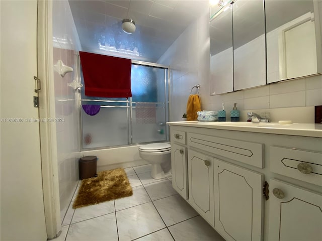 bathroom with tasteful backsplash, toilet, tile patterned floors, tile walls, and vanity