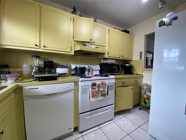 kitchen with light tile patterned floors and white appliances