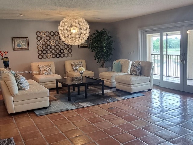 living room featuring dark tile patterned flooring, a chandelier, and a textured ceiling