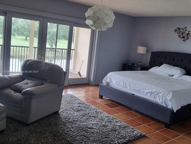 tiled bedroom with a textured ceiling, french doors, and access to exterior