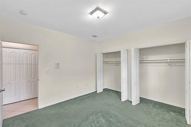 279 NW 119th Ave, Miami, FL 33182 - unfurnished bedroom with tile patterned floors, a textured ceiling, multiple closets, baseboards, and carpet