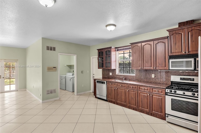 279 NW 119th Ave, Miami, FL 33182 - kitchen with independent washer and dryer, light tile patterned floors, decorative backsplash, visible vents, and appliances with stainless steel finishes