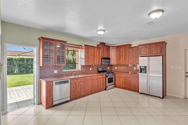 279 NW 119th Ave, Miami, FL 33182 - kitchen featuring a sink, tasteful backsplash, glass insert cabinets, stainless steel appliances, and visible vents