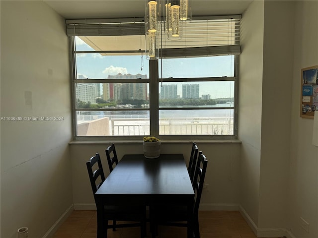 dining room with tile patterned floors and a water view