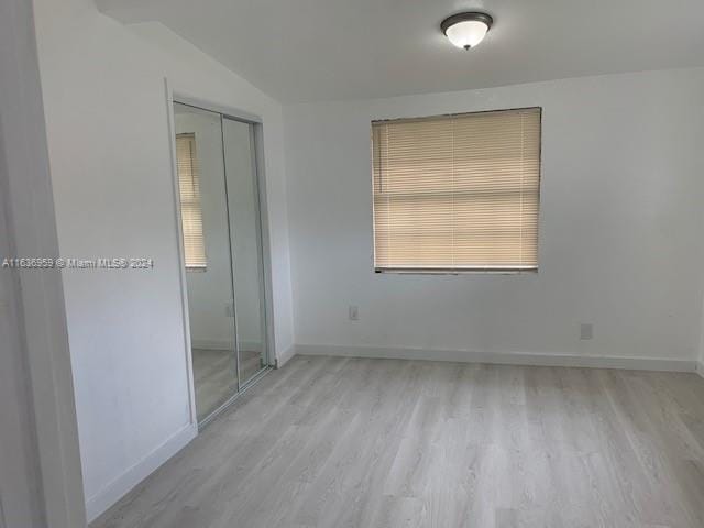 unfurnished bedroom with a closet and hardwood / wood-style flooring