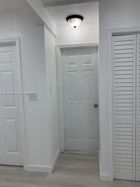 hallway with light hardwood / wood-style floors