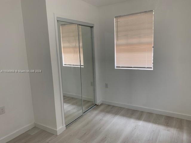 unfurnished bedroom with light hardwood / wood-style floors and a closet