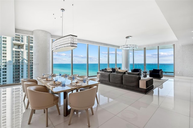 dining space with a water view, light tile patterned floors, floor to ceiling windows, and an inviting chandelier