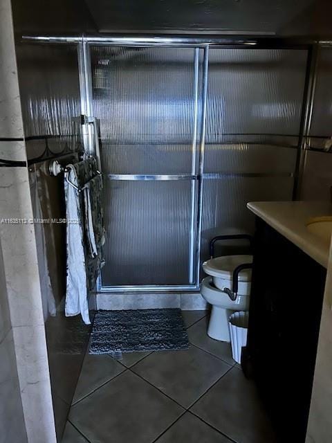 bathroom with vanity, tile patterned floors, toilet, and a shower stall