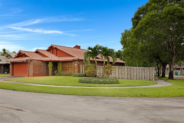 view of front of house featuring a garage and a front lawn