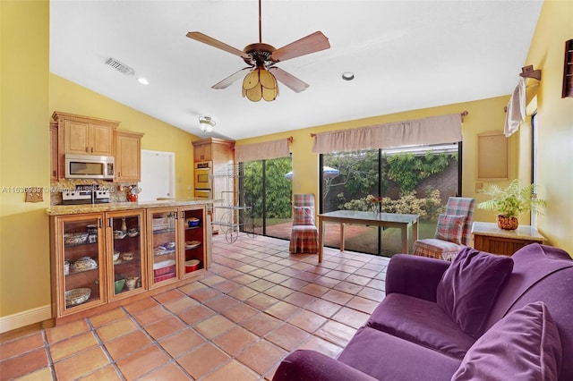 tiled living room featuring ceiling fan and vaulted ceiling