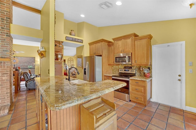 kitchen with a kitchen bar, appliances with stainless steel finishes, lofted ceiling, and sink