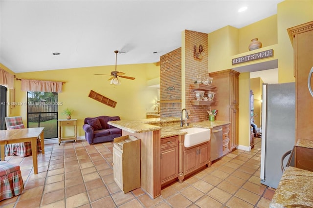 kitchen with sink, vaulted ceiling, ceiling fan, appliances with stainless steel finishes, and kitchen peninsula