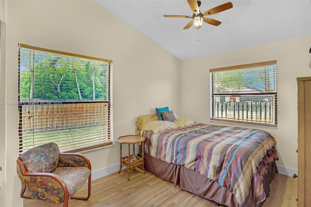 bedroom featuring ceiling fan, light hardwood / wood-style floors, and lofted ceiling