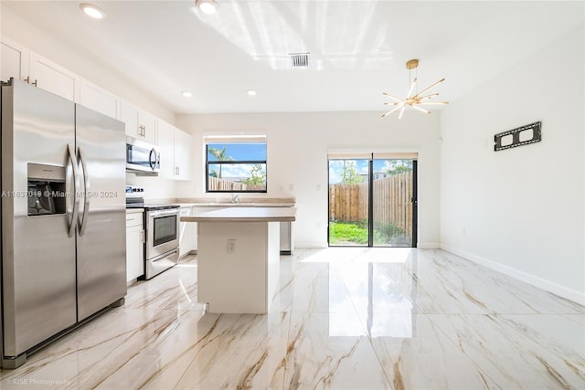 kitchen featuring white cabinets, stainless steel appliances, light tile patterned floors, and a center island