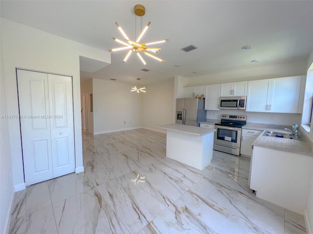 kitchen with stainless steel appliances, sink, light tile patterned floors, white cabinets, and a kitchen island